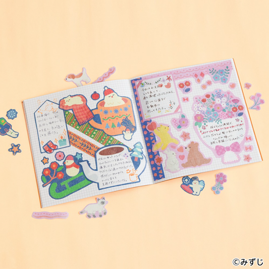 An open decorated notebook spread with colorful illustrated stickers, handwritten notes, and pastel graphics on both pages, photographed on a warm peach background with small decorative stickers scattered around.