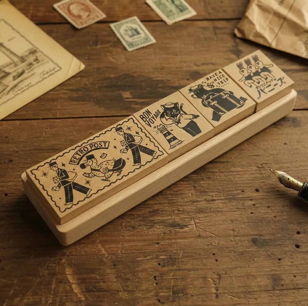 Set of vintage-style rubber stamps on a wooden surface with stamps and paper in the background.