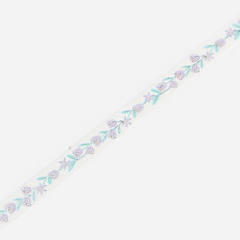 A close-up of slim masking tape featuring a delicate repeating pattern of small lavender flowers and light blue-green leaves, set against a plain light gray background.