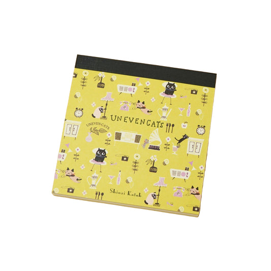Notebook with a yellow cover featuring cat illustrations and the text 'Uneven Cats' 