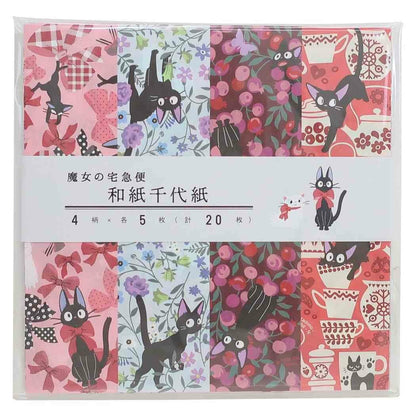 A packaged set of four Japanese origami paper sheets featuring various Kiki's Delivery Service patterns in pink, red, black, and floral colors, wrapped in a clear plastic case with a white paper band.