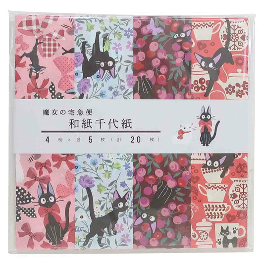 A packaged set of four Japanese origami paper sheets featuring various Kiki's Delivery Service patterns in pink, red, black, and floral colors, wrapped in a clear plastic case with a white paper band.