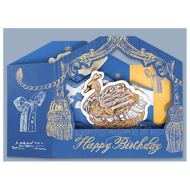 A blue and gold birthday card with a pop-up swan illustration and the words 'Happy Birthday' in gold script, shown against a light gray background