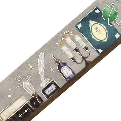 Decorative washi tape with illustrations of candles, bottles, and other elements on a gray background.