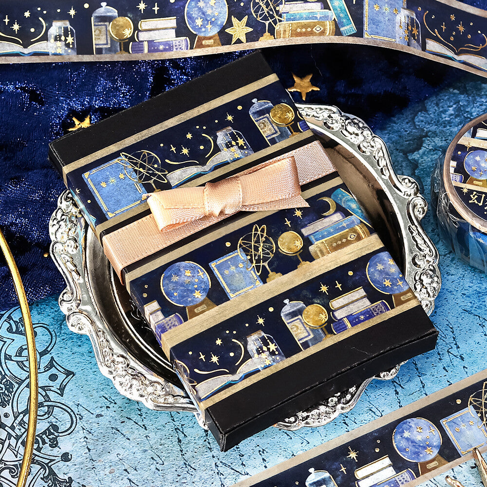 Decorative stationery with celestial design and pink bow on a blue textured surface