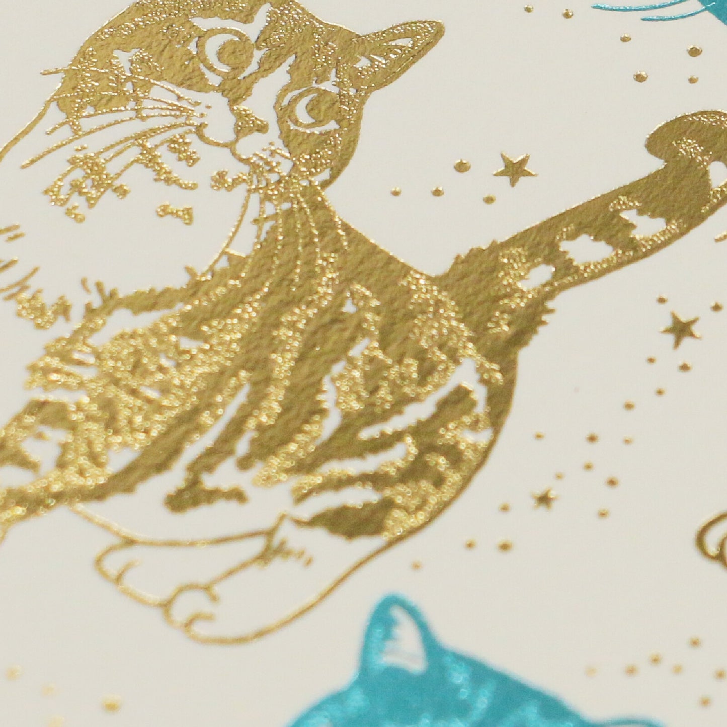 Gold foil cat illustration on a white background with stars