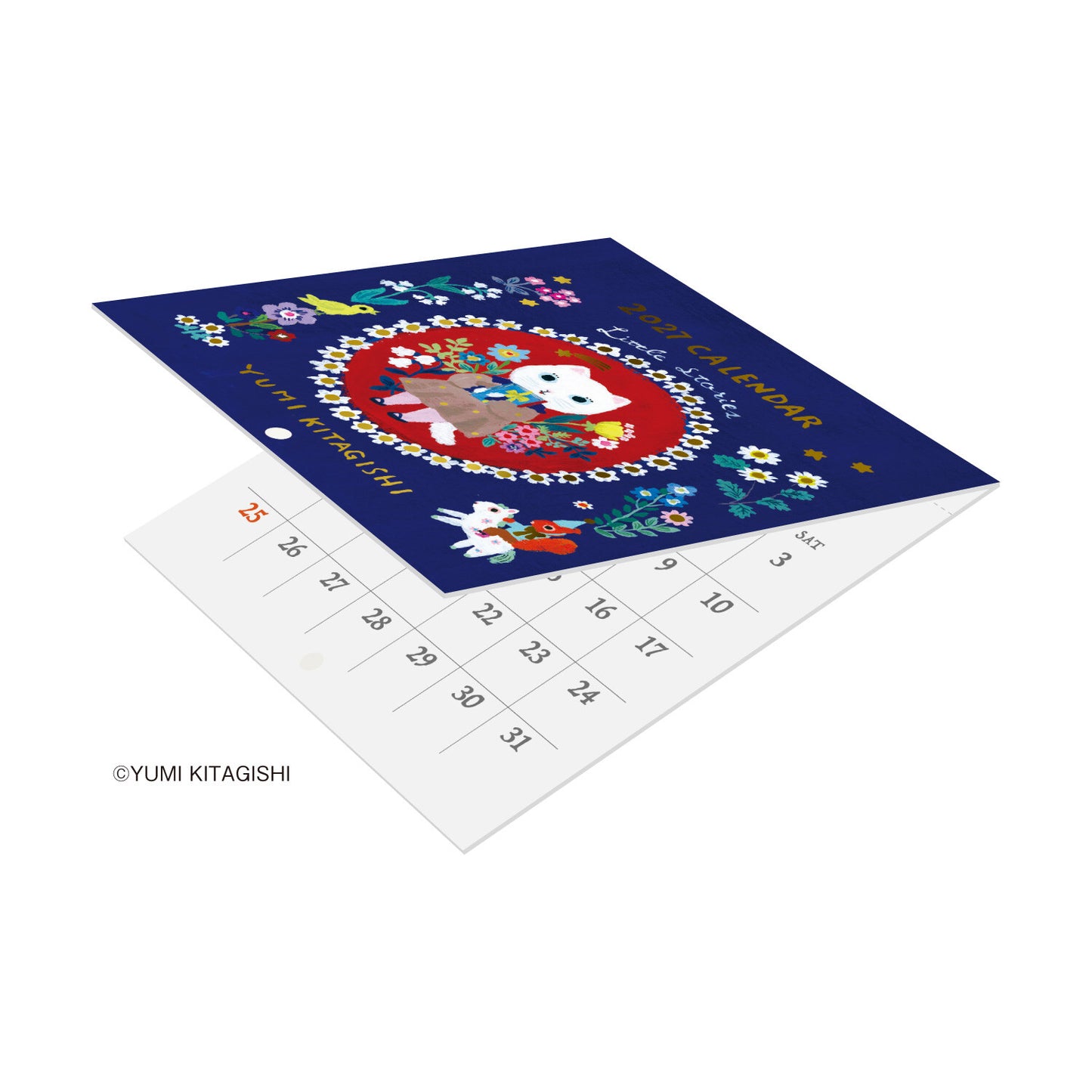 A folded calendar featuring a colorful illustrated cover with a white cat in a floral wreath on a dark blue background, layered over a white calendar-style page with printed numbers. The image is shown on a clean white background with a small copyright watermark reading YUMI KITAGISHI.
