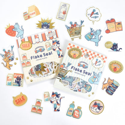 Set of Flake Seal packaging with cartoon cat illustrations on a white background