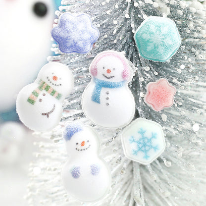 Three white snowman-shaped stickers with colorful scarves and faces, plus three snowflake-shaped stickers in pastel blue, pink, and mint, displayed on a white glittery Christmas tree.