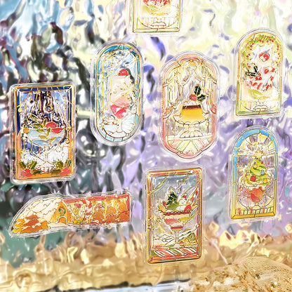 A set of colorful, stained-glass-style decorative stickers with illustrated winter and festive scenes, arranged on a reflective iridescent surface.