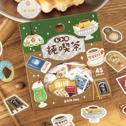 A package of Coffee Shop themed stickers or decals displayed on a wooden tabletop with other coffee-themed stickers scattered around.