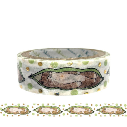 A roll of decorative washi tape with a cat inside a pod illustration and green and gold polka dots, shown on a white background and a strip of the tape pattern below.