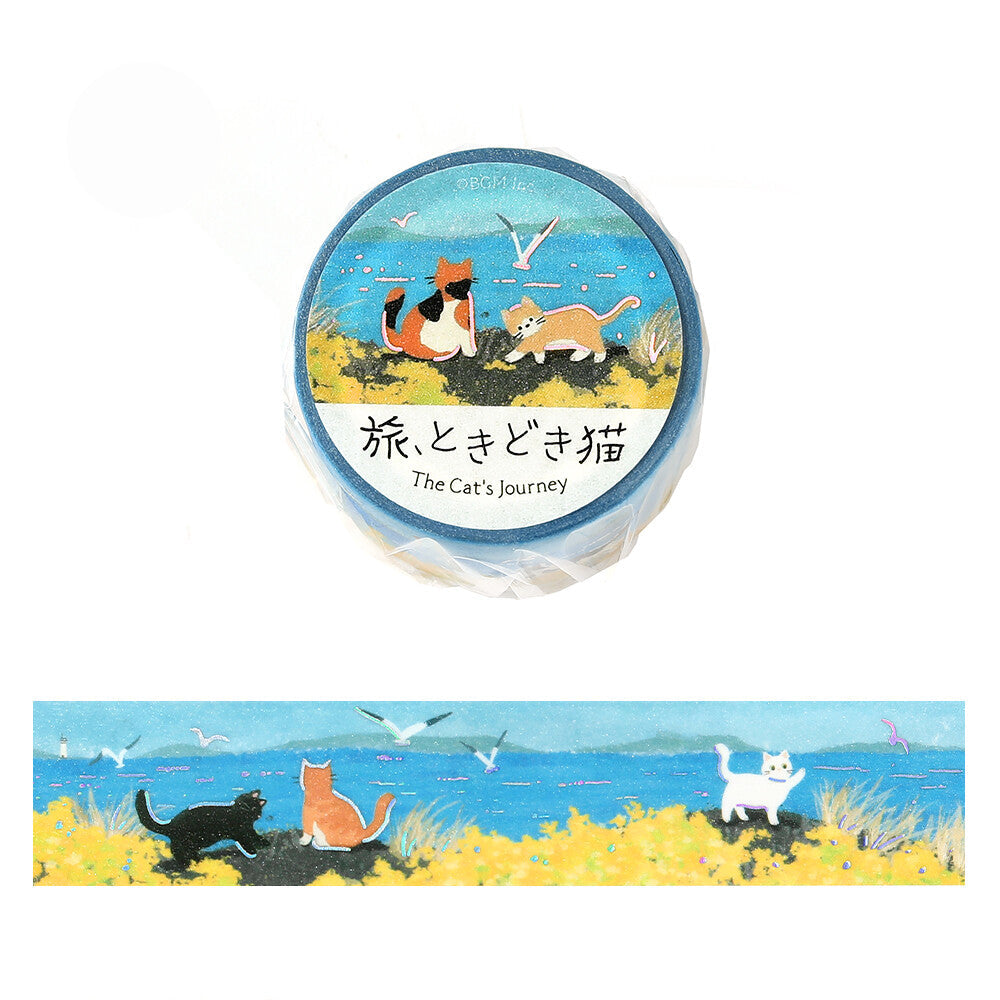 A roll of decorative washi tape with a blue label featuring two cats by the sea, shown above a long strip preview of the same design. 