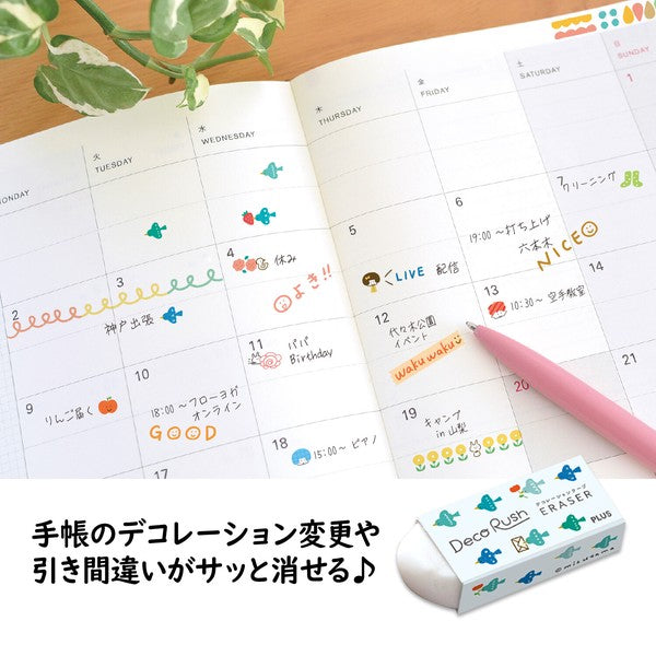 A close-up of an open planner showing decorated calendar days with colorful stickers and a pink pen, alongside a small box of Deco Rush erasers. Japanese text appears along the bottom.
