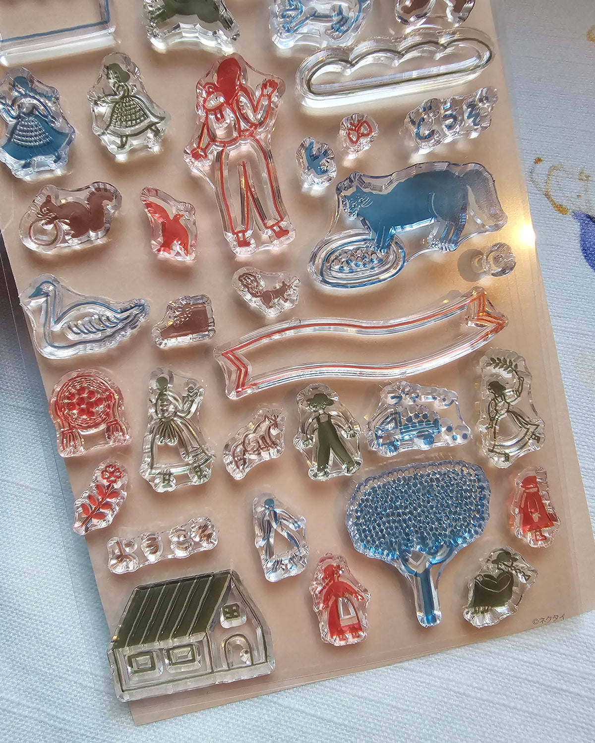 A package of Necktie clear stamps featuring various animal and decorative shapes in red, blue, green, and silver, with a green header card displaying Japanese text and illustrations.