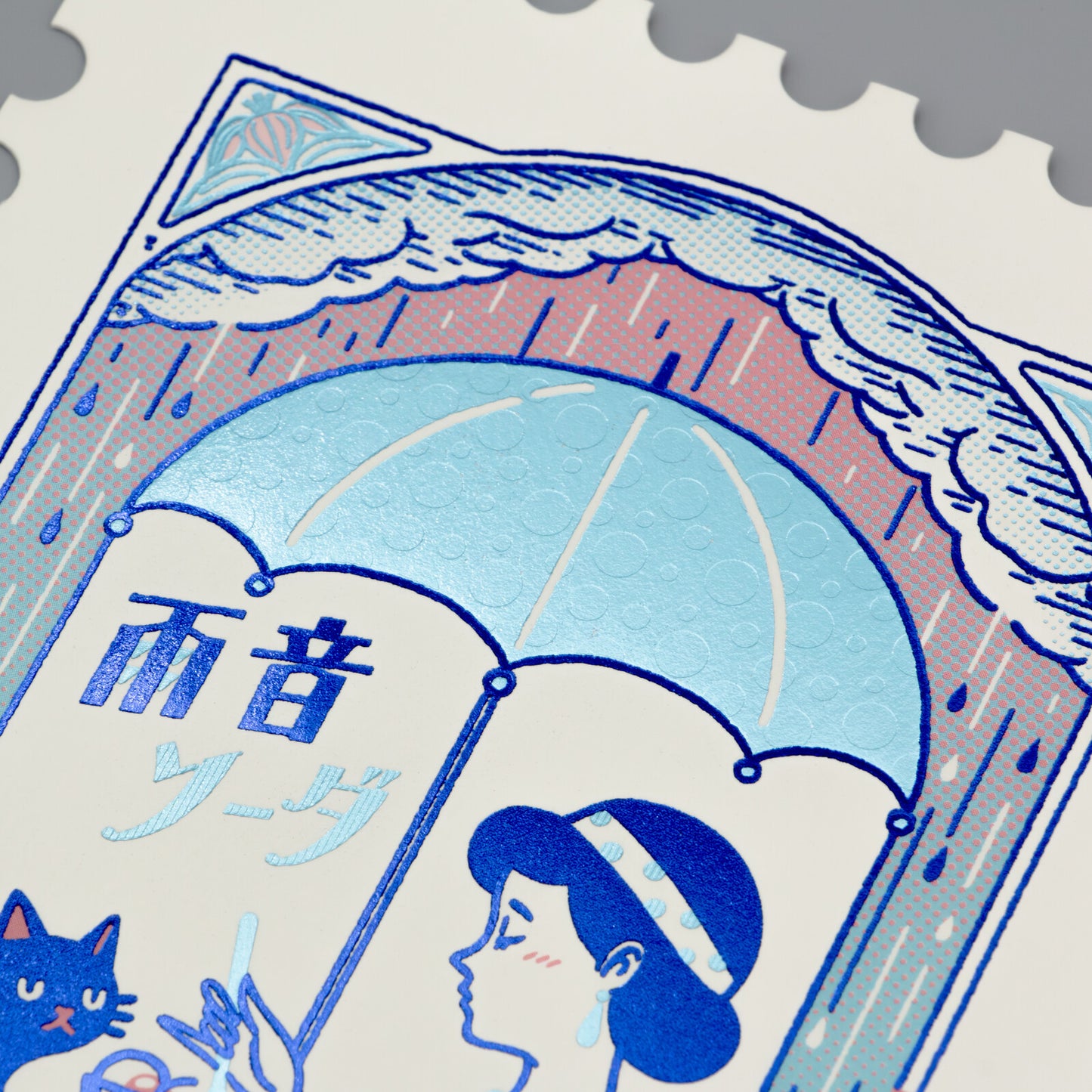 Stylized illustration of a woman, cat, and umbrella with Japanese text on a foil-stamped postcard.