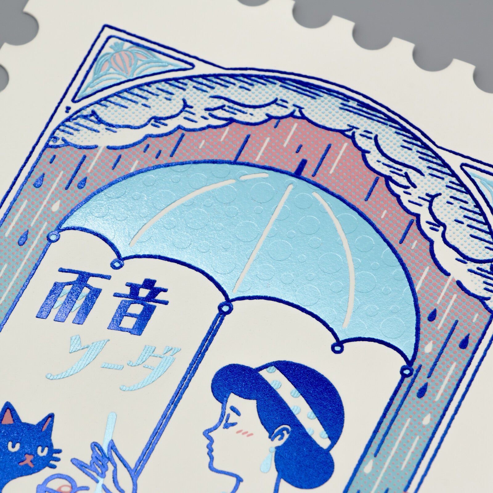 Stylized illustration of a woman, cat, and umbrella with Japanese text on a foil-stamped postcard.