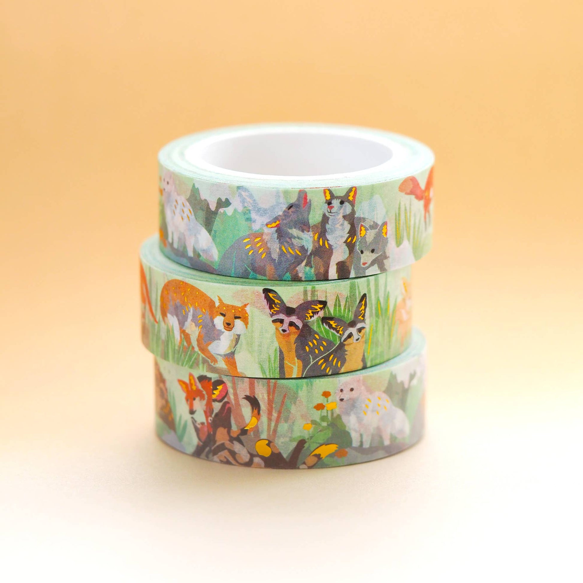 Three rolls of washi tape with animal designs on a gradient background