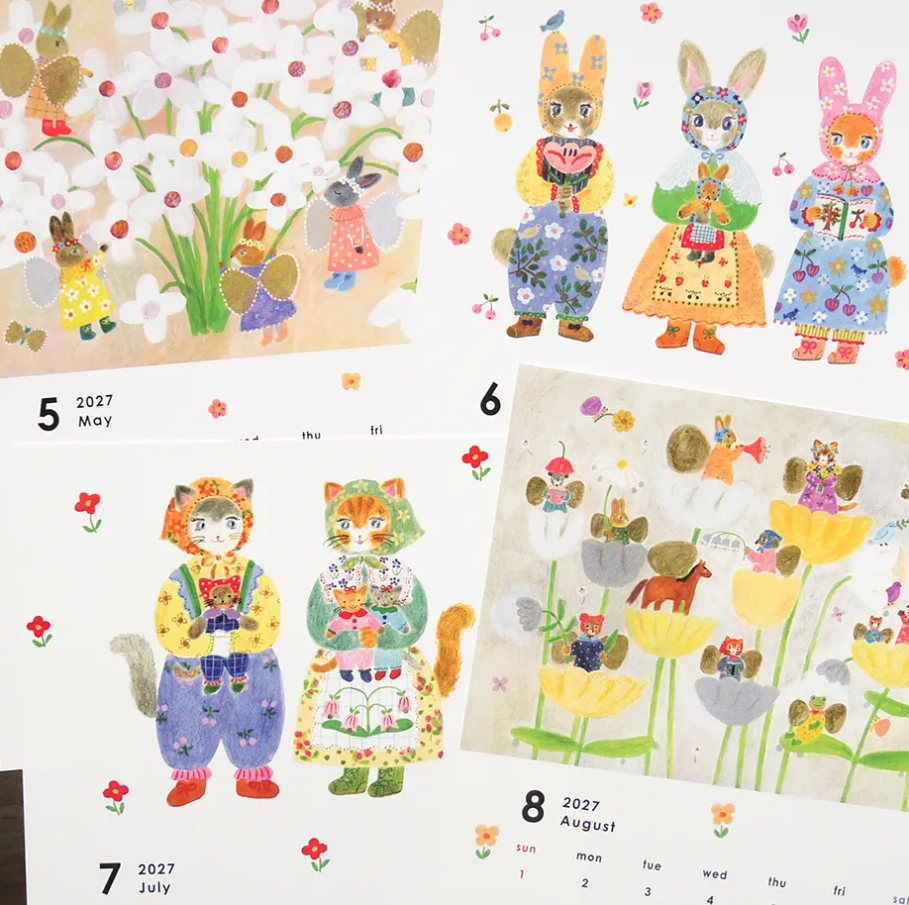 A close-up of a printed illustrated calendar pages showing multiple monthly pages with cartoon animals in floral clothing, including bunnies, cats, a fox, and a rabbit holding a basket. 
