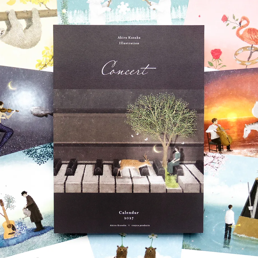 A square calendar titled "Concert" by Akira Kusaka, shown upright against a collage of whimsical illustrated scenes. The calendar cover is dark charcoal with piano keys, a tree, a deer, and a seated figure.
