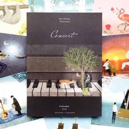 A square calendar titled "Concert" by Akira Kusaka, shown upright against a collage of whimsical illustrated scenes. The calendar cover is dark charcoal with piano keys, a tree, a deer, and a seated figure.