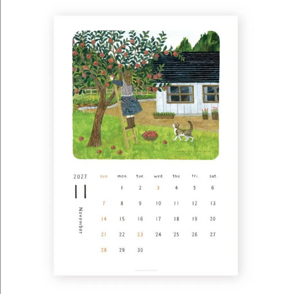 A single-page 2027 calendar print showing November with an illustrated apple orchard scene above the calendar grid. The artwork depicts a person climbing a ladder toward an apple tree next to a white cottage, with a cat in the foreground.
