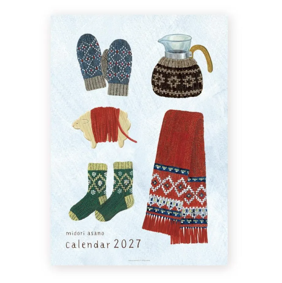 A 2027 wall calendar titled 'midori asano calendar 2027' featuring a light blue textured background with illustrations of winter items: navy patterned mittens, a brown knit sweater-covered pitcher, a red knit sheep, green patterned socks, and a red scarf with blue and white geometric borders.