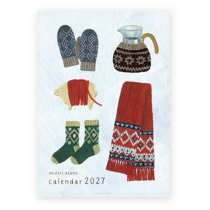 A 2027 wall calendar titled 'midori asano calendar 2027' featuring a light blue textured background with illustrations of winter items: navy patterned mittens, a brown knit sweater-covered pitcher, a red knit sheep, green patterned socks, and a red scarf with blue and white geometric borders.