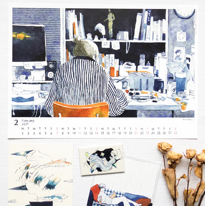 A printed calendar page showing a blue-toned illustration of a person sitting at a desk, with a February 2027 date strip along the bottom. Surrounding the calendar are smaller artwork samples and dried flowers on a light surface.