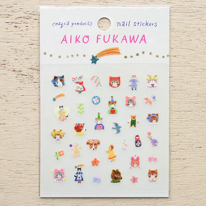 A sheet of Aiko Fukawa nail stickers featuring cute cartoon characters, animals, and flowers on a white backing card, displayed on a light wood background.