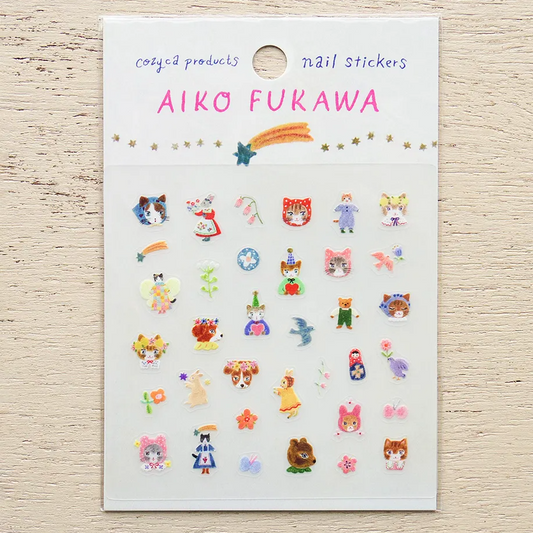 A sheet of Aiko Fukawa nail stickers featuring cute cartoon characters, animals, and flowers on a white backing card, displayed on a light wood background.