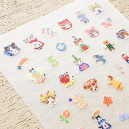 A collection of small, colorful nail stickers featuring various cute characters, animals, and flowers, arranged neatly on a light beige background.