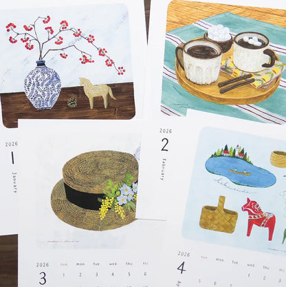 Calendar with illustrations of a vase, horse, coffee cups, hat, and other items on a table.