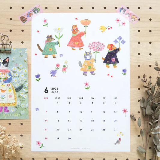 Calendar for June 2024 with illustrations of cats and flowers on a wooden surface.